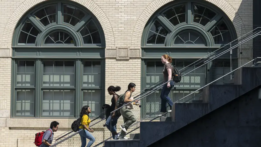 Students walk past a large set of windows on CMU campus.