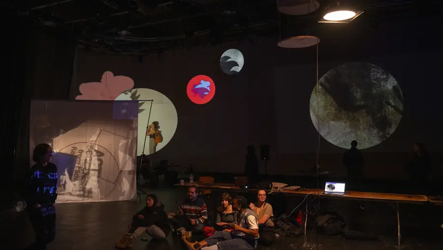 students sitting on studio floor looking at projected images