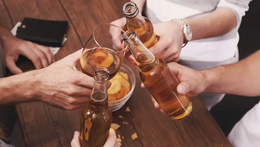 Multiple people holding alcoholic beverages together