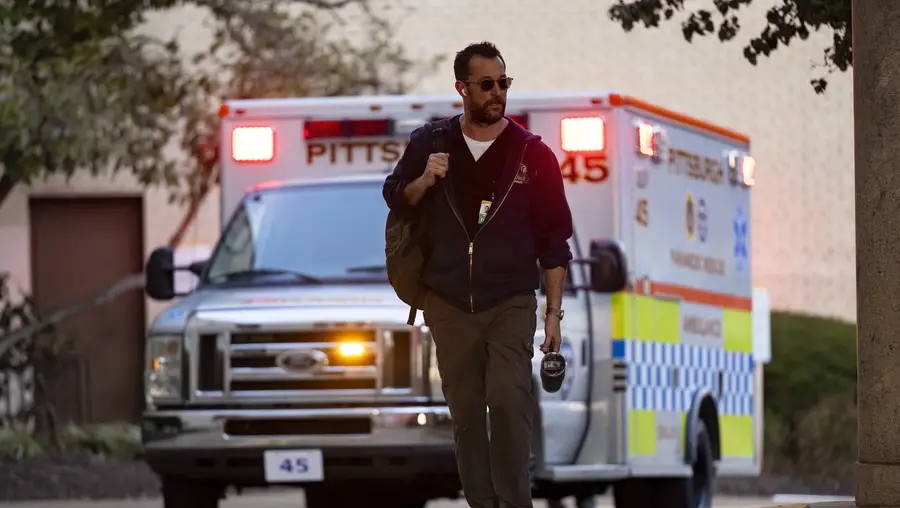 A man walking in front of an ambulance 