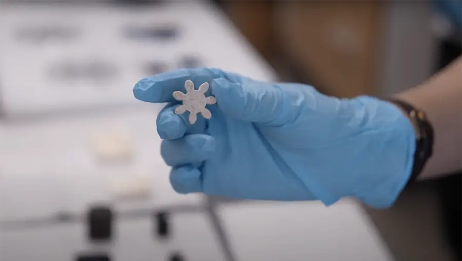 Gloved hand holding a star-shaped MXene.