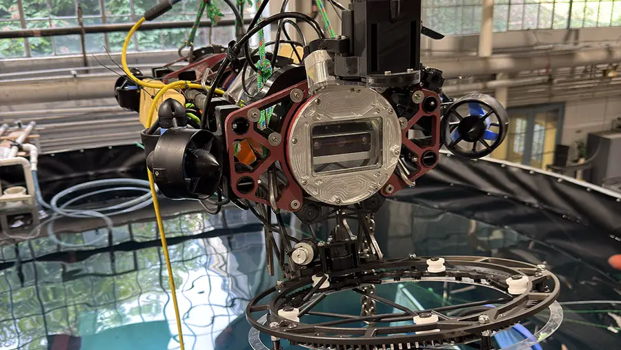 The Kingfisher autonomous submersible is held above the water tank for testing.