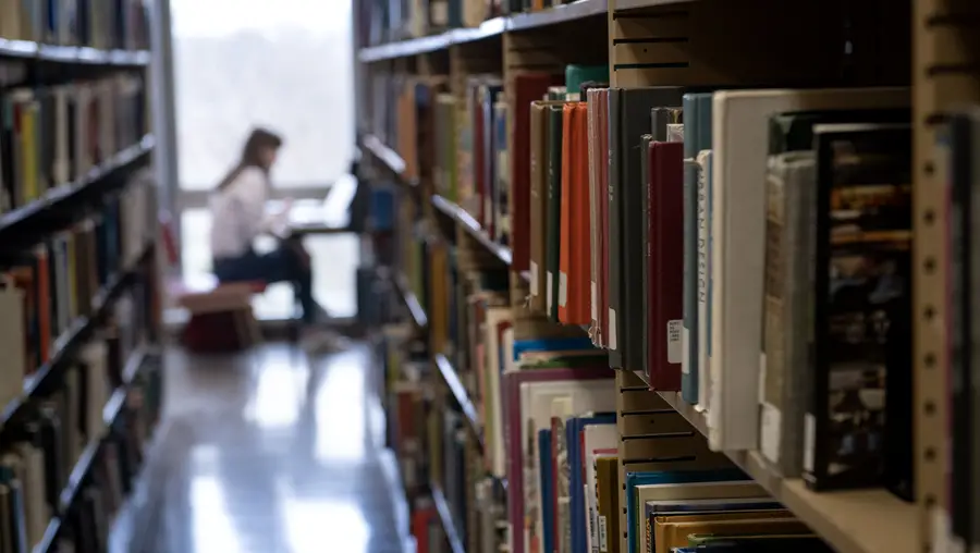 A student reading inside a library. 