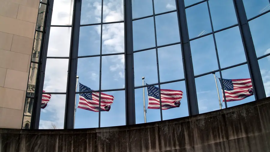 Exterior photo of the SEI building with four American flags