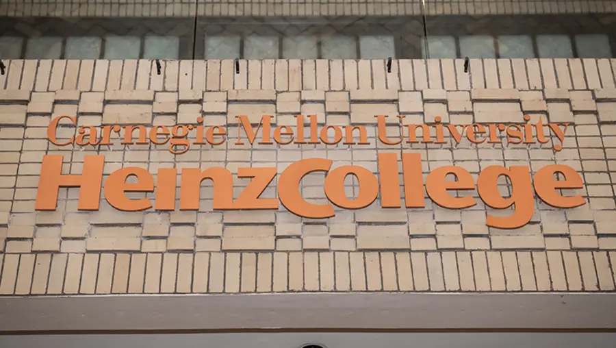 Signage with orange letters that says "Carnegie Mellon University Heinz College"