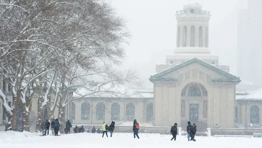 Students walk through CMU campus on a snowy day. 