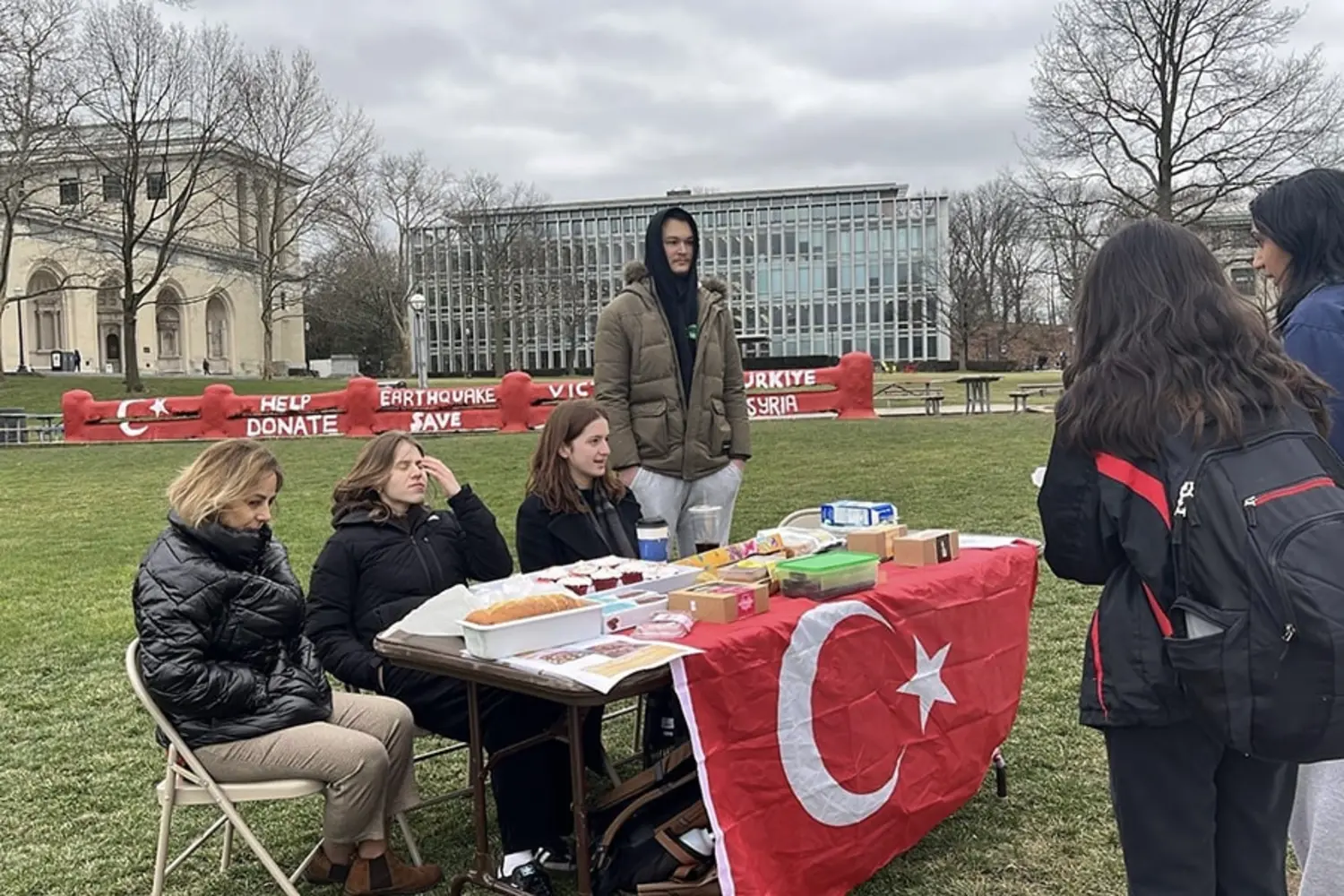 Students sit at a table outside.