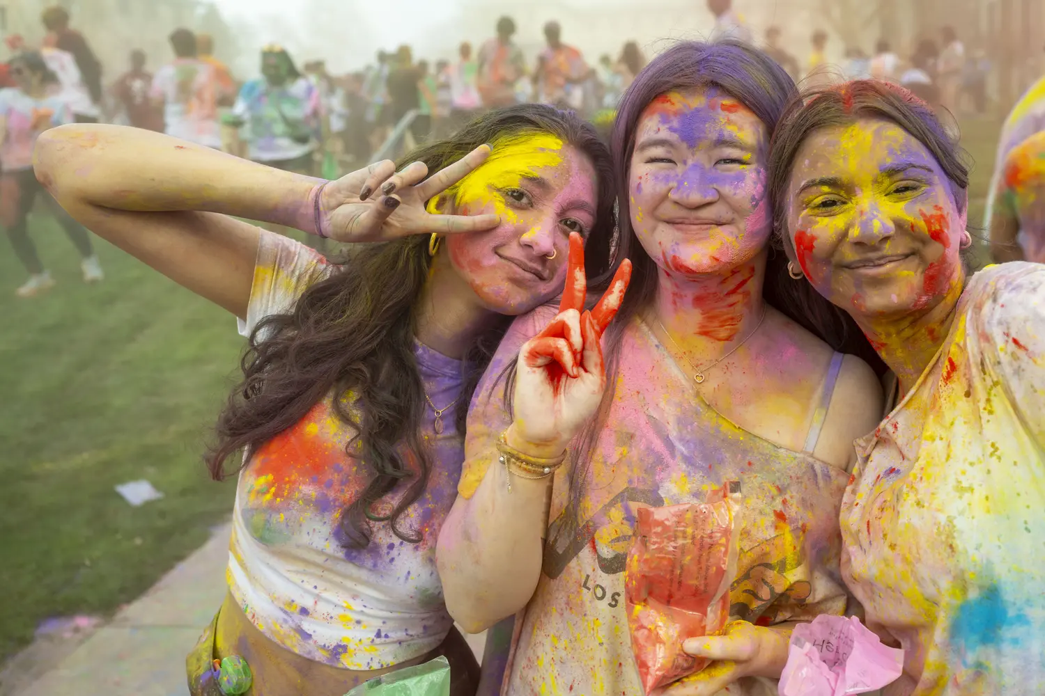 Three CMU students emerge colorful from a Holi celebration.