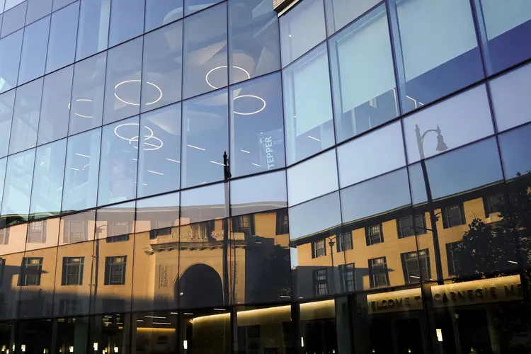 Hamburg Hall reflected in the Tepper Building's windows. 