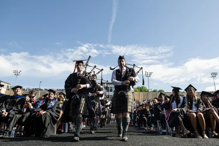 Bagpipers lead the procession.