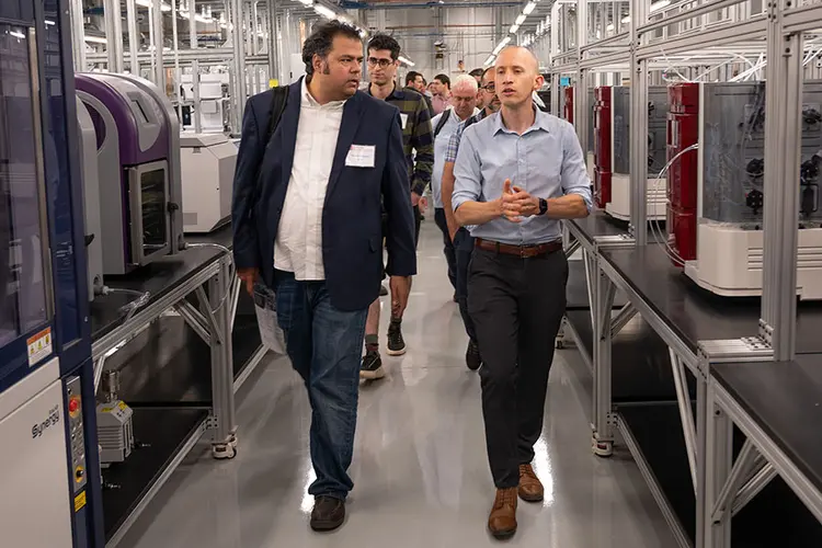 Two people walking between machinery