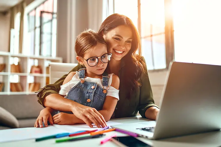 mother and daughter looking at laptop screen together