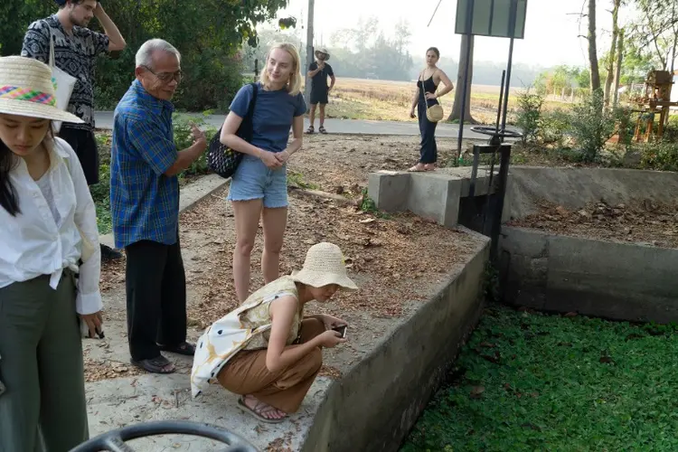 students and villager overlooking the canal