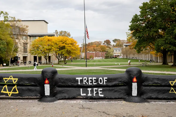 Fence on CMU campus painted black with candles and Tree of Life