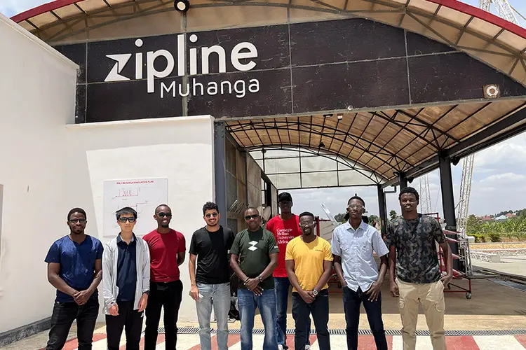 group of people standing in front of Zipline building sign