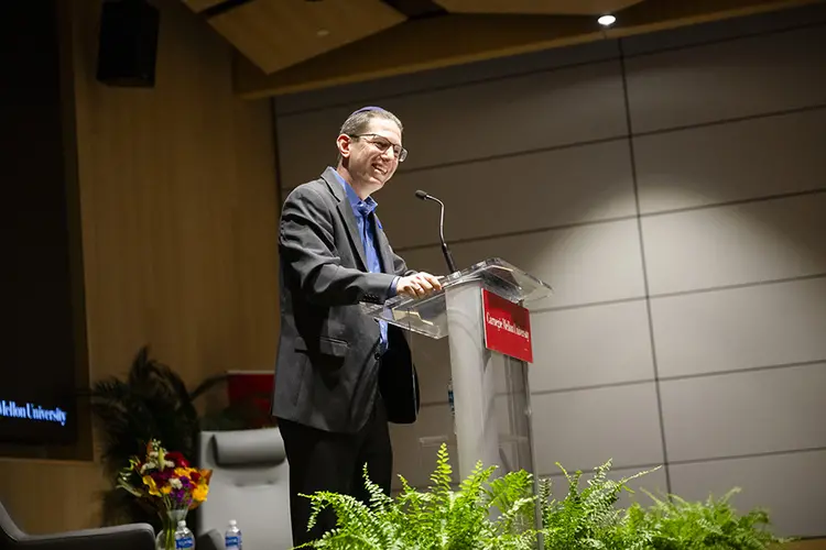 Rabbi Charlie Cytron-Walker standing at podium