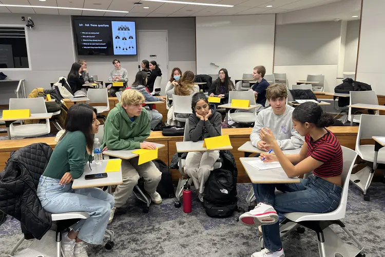 view of classroom focused on five students seated at their desks in a semicircle