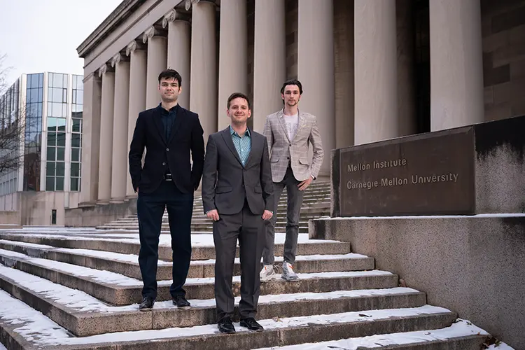 three men standing on steps of Mellon Institute