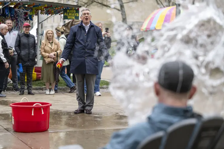 Provost Jim Garret throws a ball at the Douse-a-Dean competition.