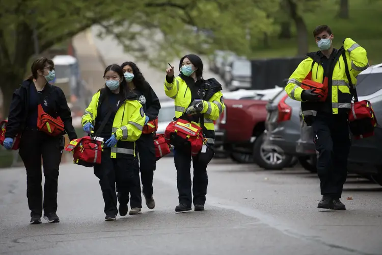 five emergency responders walk together wearing high visibility gear