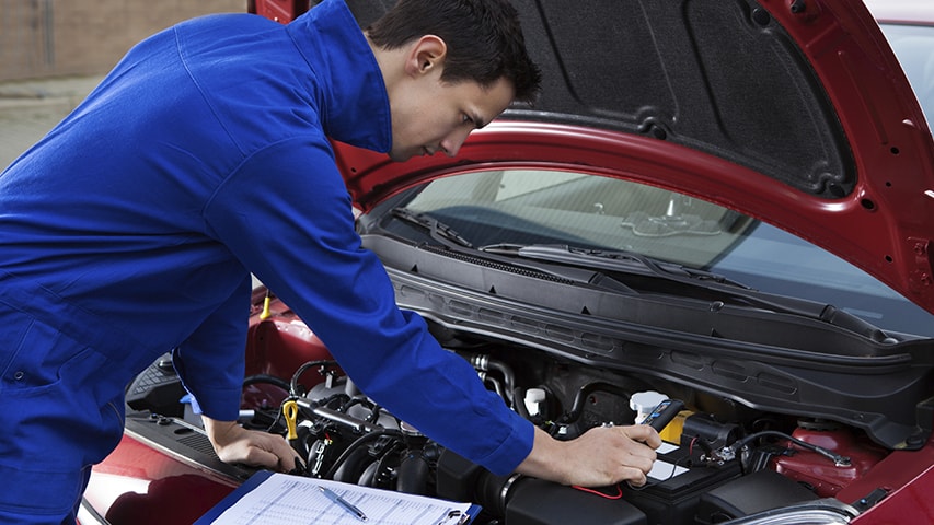 man inspecting car