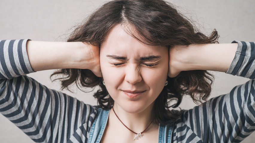 Image of woman holding her hands over her ears