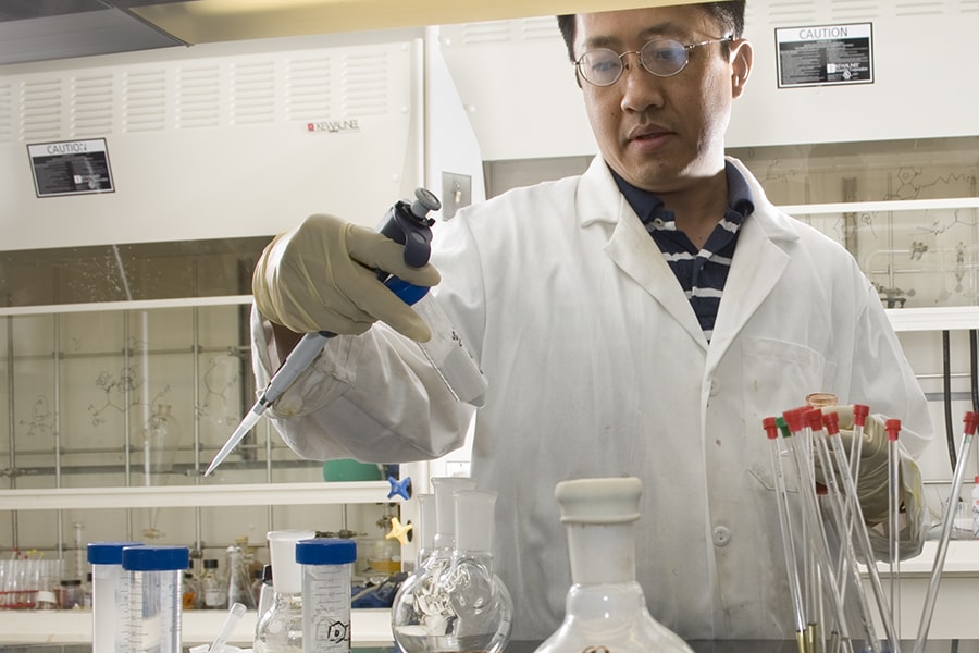 CMU scientists examine a vial