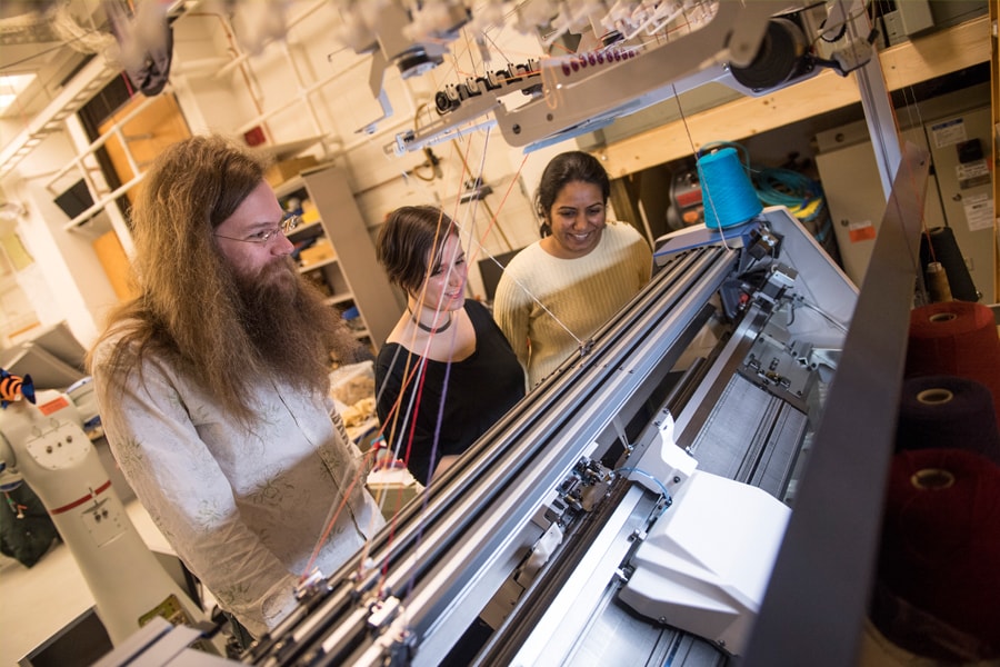 Image of researchers watching a knitting machine