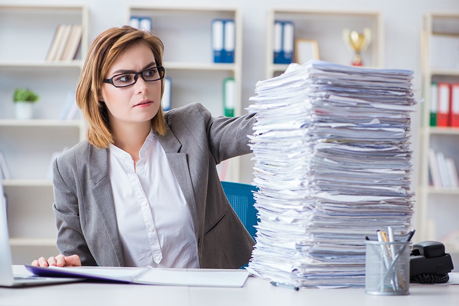 Image of woman with a pile of paperwork