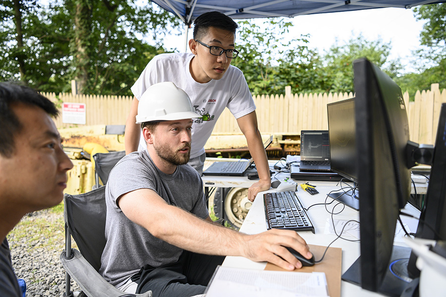 A photo of researchers at a computer screen.