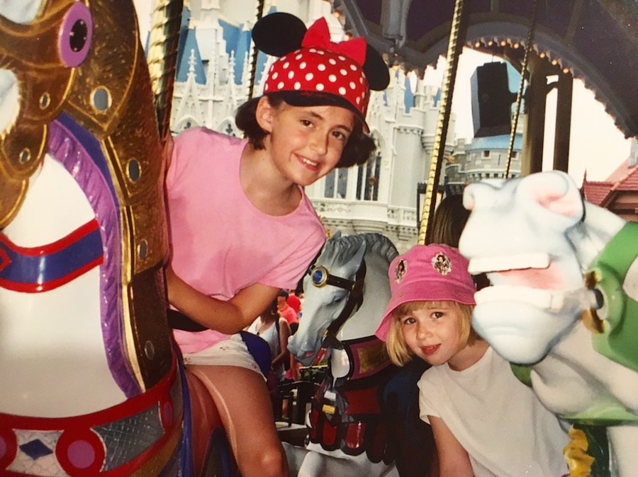 two children ride a carousel at Disney's magic kingdom