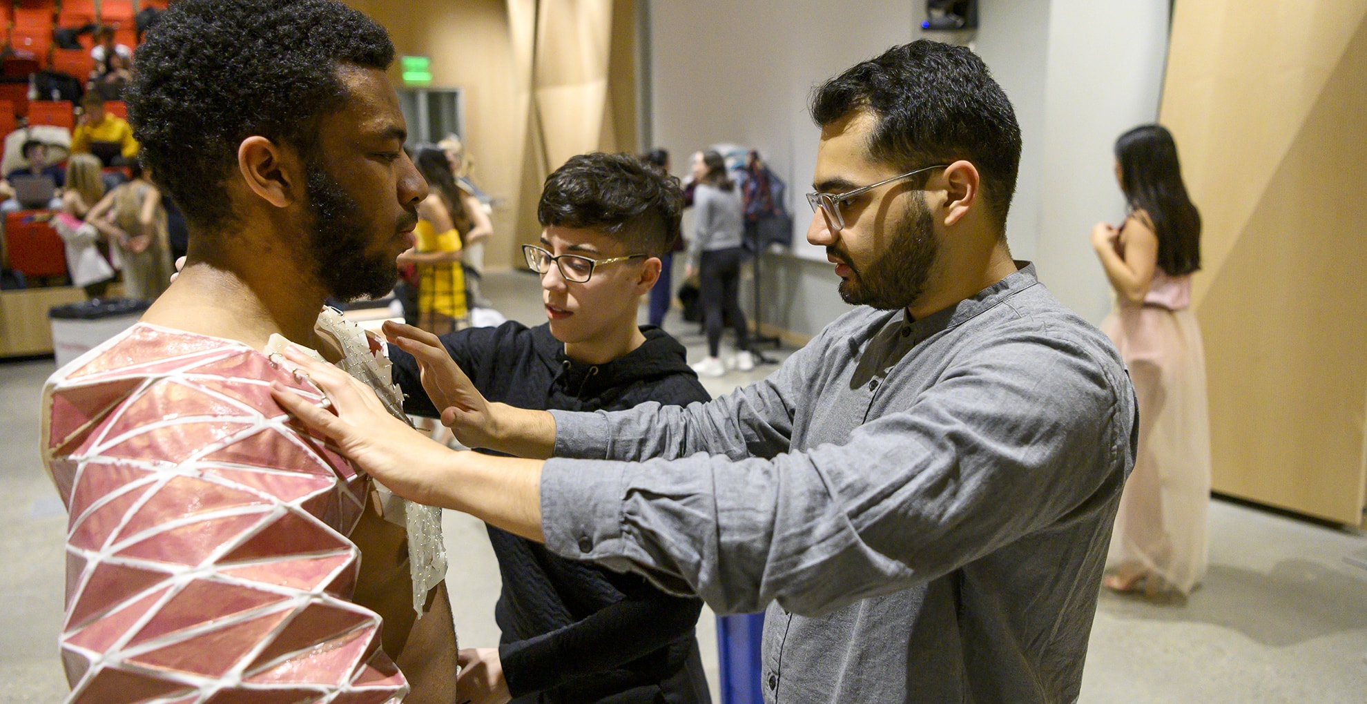 Zain adjusts the sleeves on a model