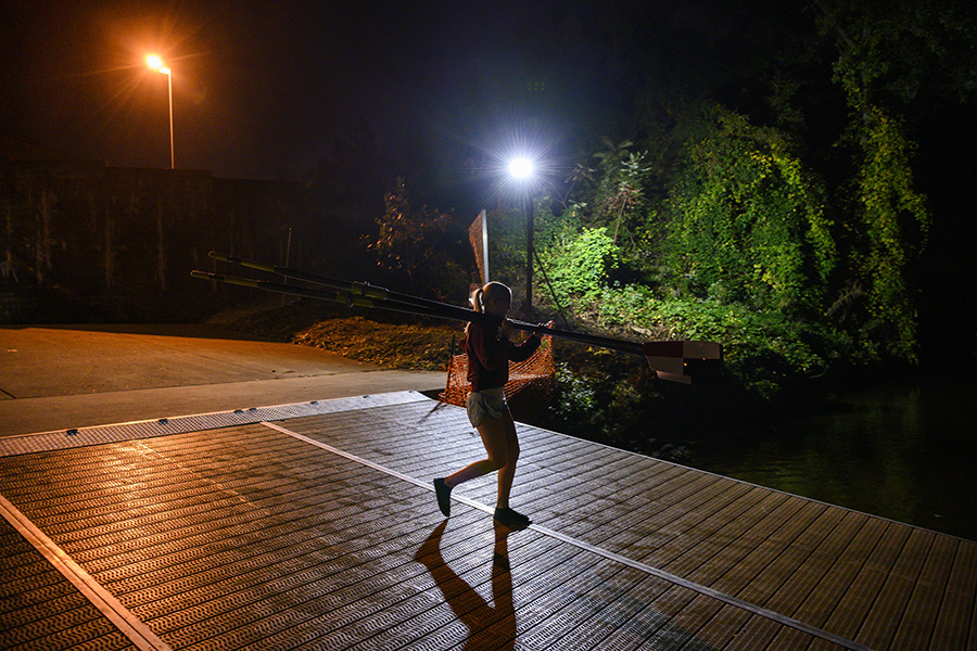 A student carries oars to the water