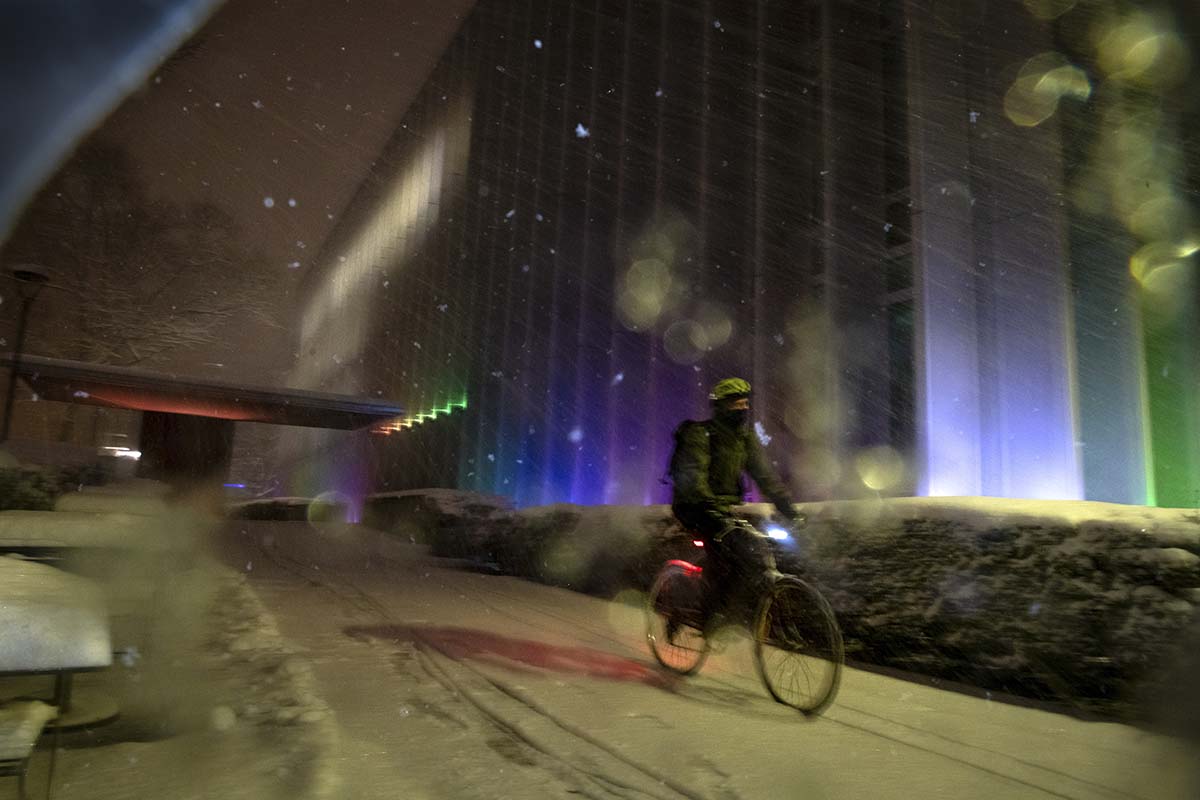 A bike rider trudges through campus