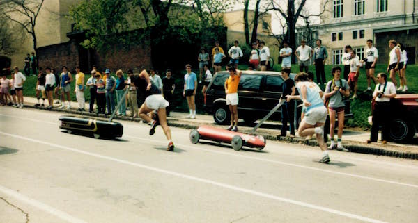 two men push a black and a red Buggy