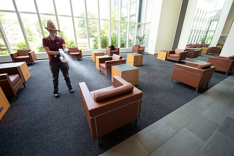 image of custodian spray-cleaning the Lee Lobby area chairs in Cohon Center