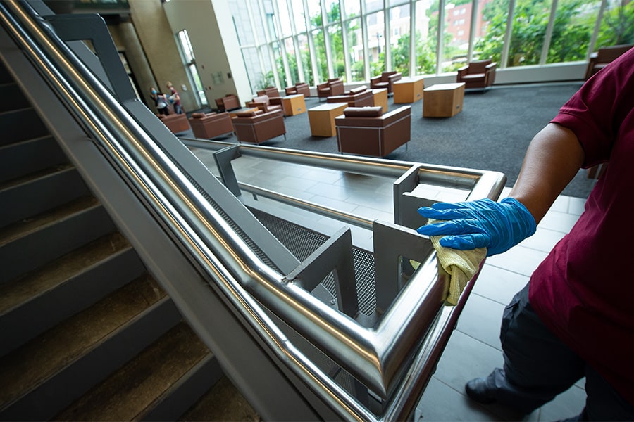 image of custodian cleaning handrail in Lee Lobby