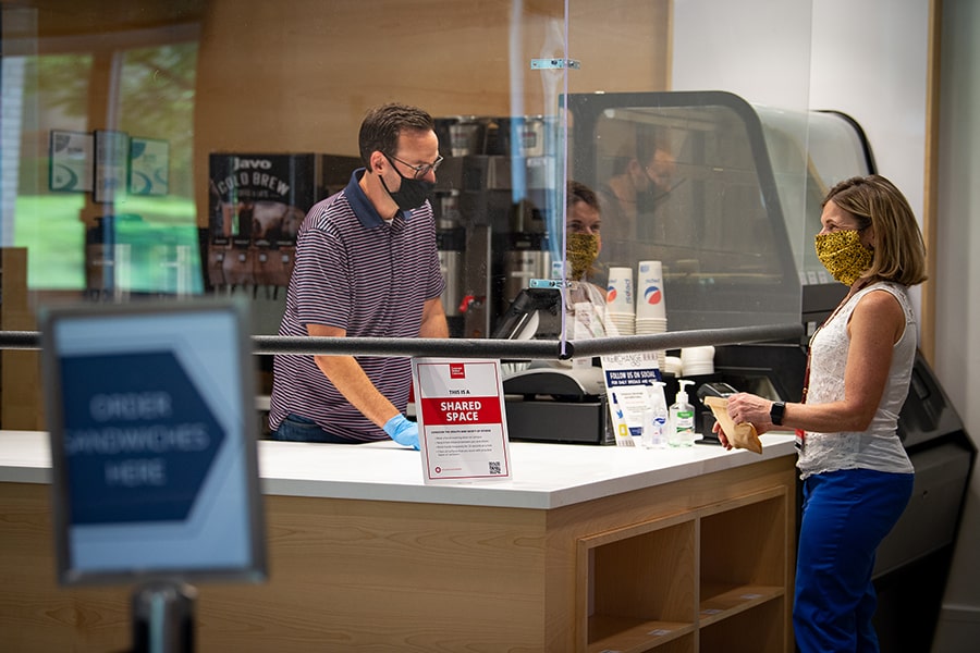 image of Dawn Roerink at a service counter with a plexiglass shield