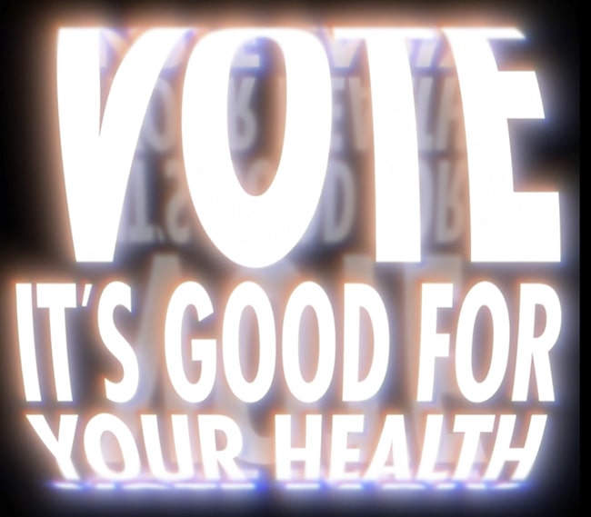 A photo of one of Jenny Holzer's projections that reads "Vote: It's good for your health"