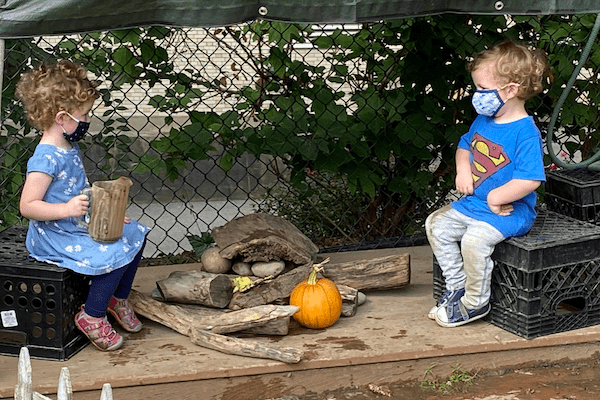 children wearing masks converse outdoors