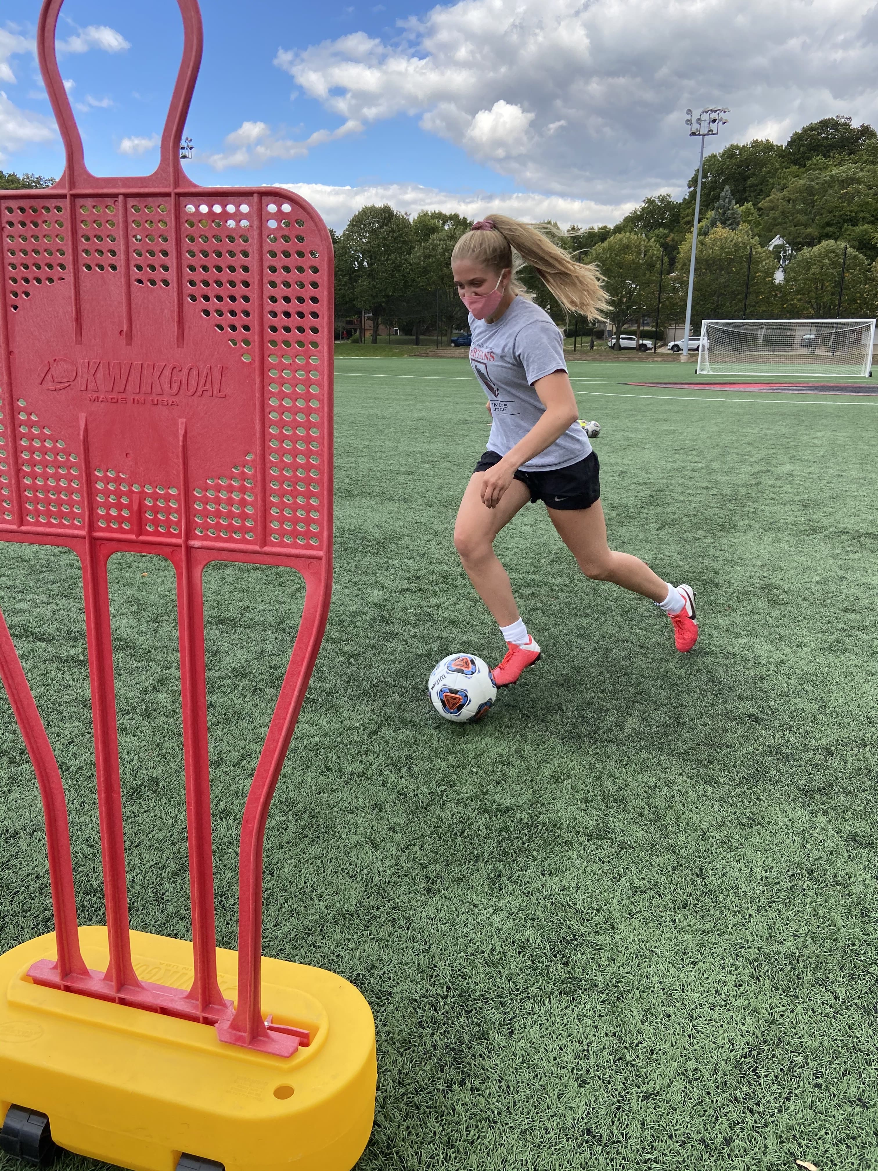 first-year soccer player Sarah Scoles approaches a red metal obstacle on the soccer field