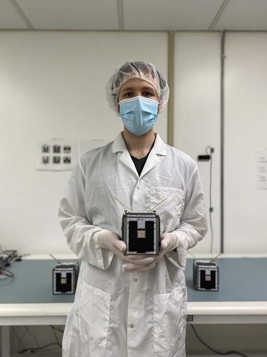 A photo of Zac Manchester holding one of the satellites