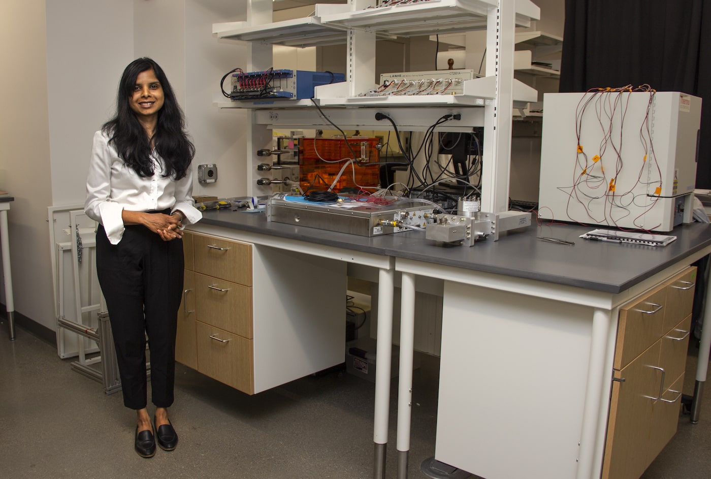 Jayan stands in front of her equipment