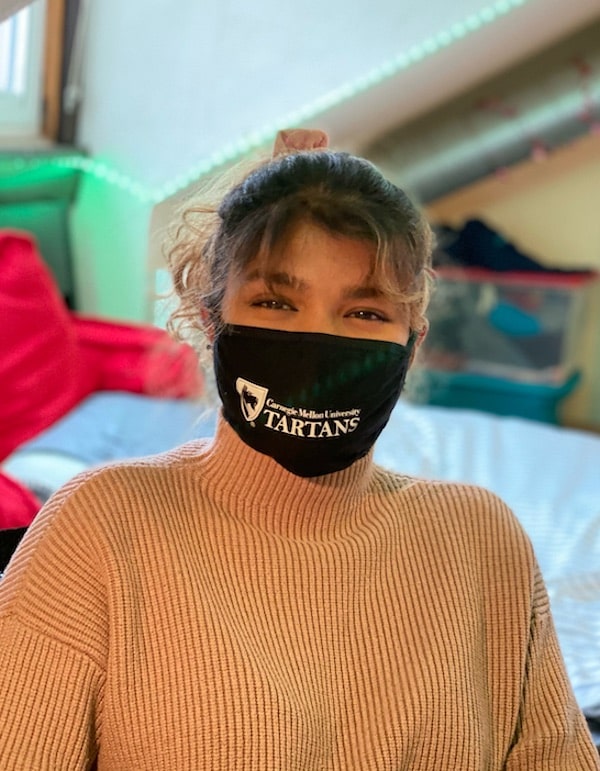 Emily George wearing a mask in her apartment