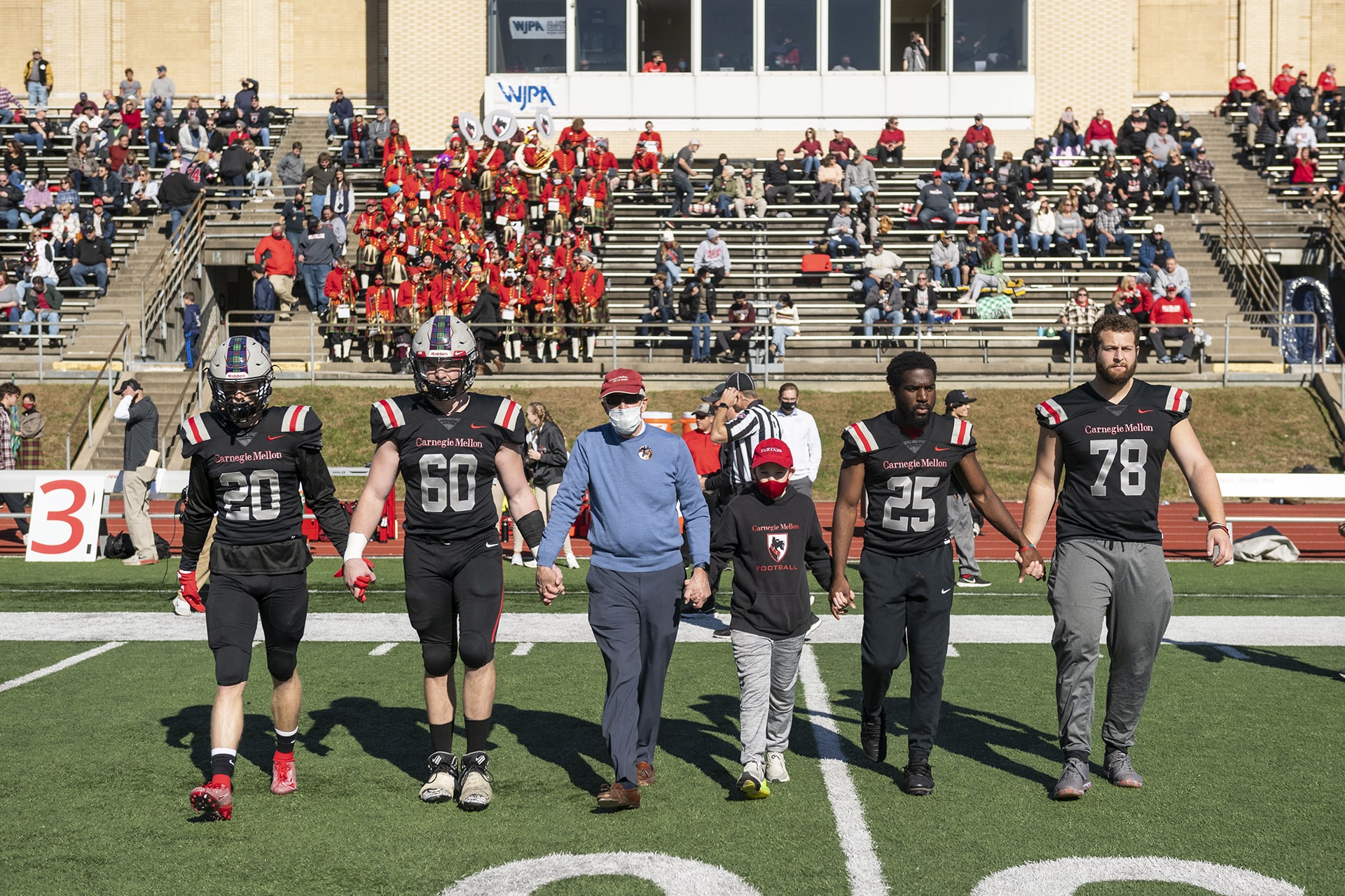 Team captains walk hand in hand to the coin toss