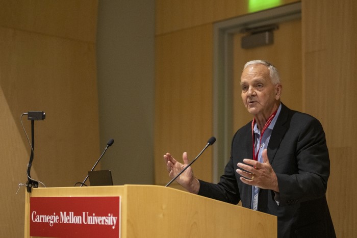 Brainplay speaker standing at the podium while lecturing. 