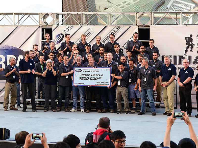 National Robotics Engineering Center (NREC) group celebrates with giant check.