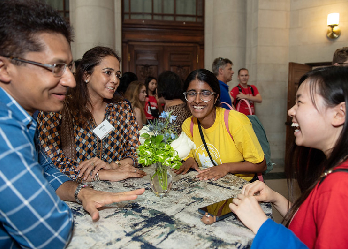 Students sitting at table laughing and talking