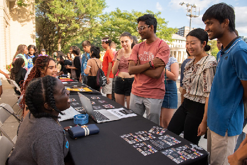 Students gather outside at a tabling event