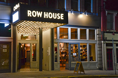 Front of the Row House Cinema lit up at night as seen from the street